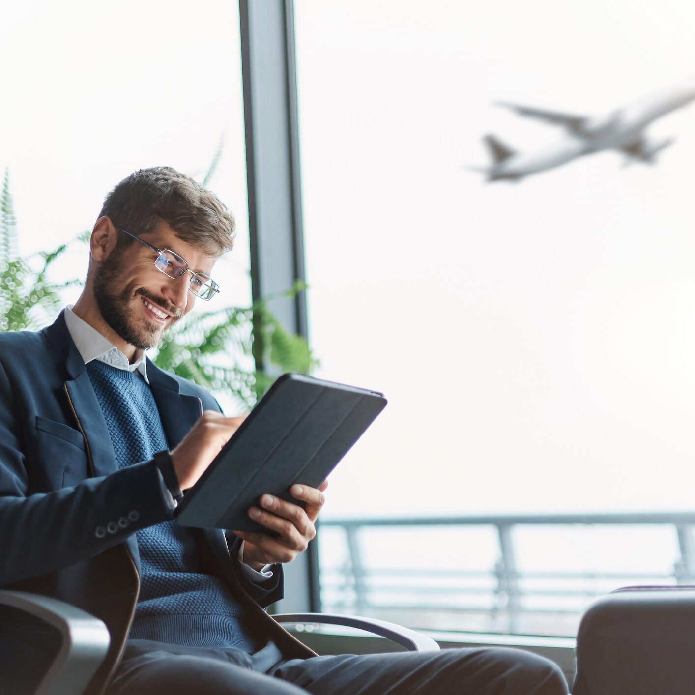 A man sitting in front of an airplane window.