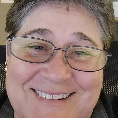 Resized_Resized_20231013_231748 A woman with glasses smiling for the camera.